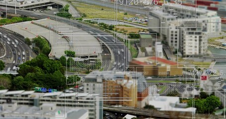 Showing aerial highway interchange curving over urban area, with vehicles, digital overlays
