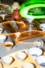 Traditional tea ceremony with clay teapot, cups and herbal tea on wooden table, authentic Asian cultural ritual
