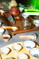 Traditional tea ceremony with clay teapot, cups and herbal tea on wooden table, authentic Asian cultural ritual