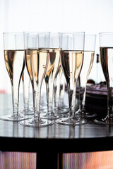 Close-up of champagne glasses filled with sparkling wine, elegant celebration table setting for festive party, wedding, New Year or luxury corporate event