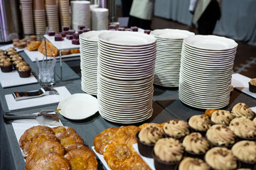 Catering banquet table with assorted snacks, desserts, pastries and appetizers, luxury food service arrangement for corporate event, wedding or festive celebration