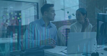 Analysts in blue shirt, white top reviewing financials in office, with laptop chart overlays