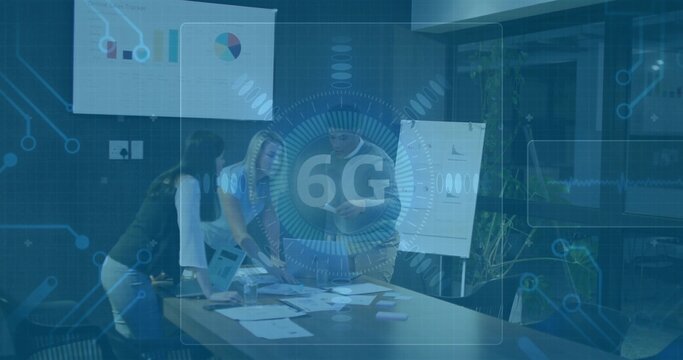 Reviewing printed charts and using laptop while team collaborating in meeting room, with 6G overlay - Powered by Adobe