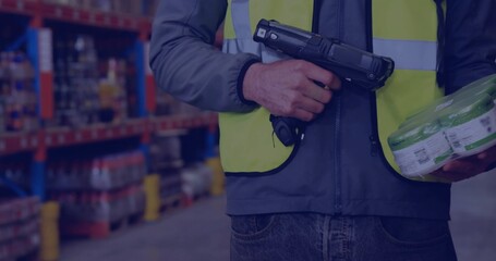 Scanning worker wearing safety vest using barcode scanner in storage aisle with product pack