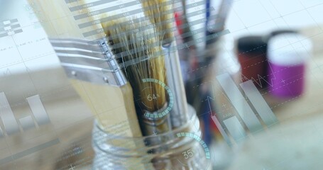 Displaying clear glass jar with paintbrushes on wooden desk projecting digital data overlays