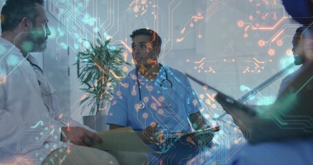 Doctors in coats and scrubs reviewing yellow file in hospital lounge, with tablet and stethoscope