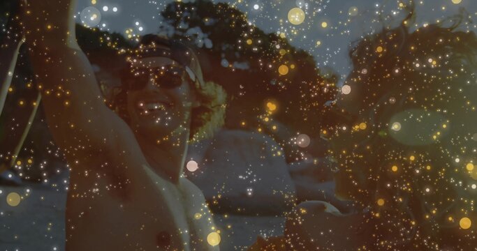 Shirtless man waving on boat at lake with sunglasses backward baseball cap golden bokeh, copy space