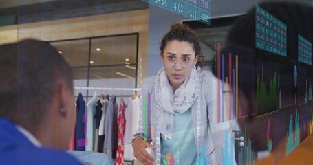Presenting woman with glasses and measuring tape at studio, showing chart overlays, clothing rack