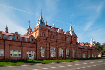 An old red brick building against a blue sky on a clear sunny day. Sights of Russia, World tourism.
