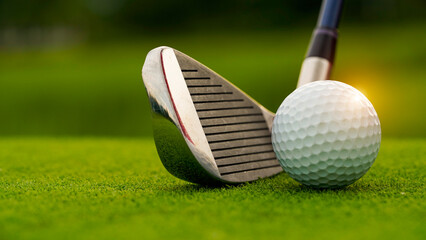 Golf clubs and balls on a green lawn in a beautiful golf course with morning sunshine.