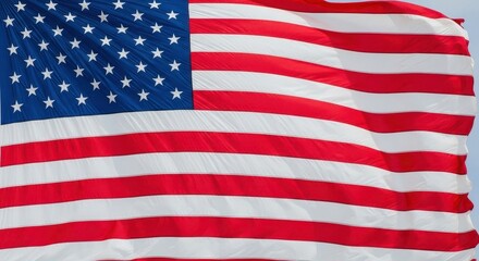 Fototapeta premium Waving American Flag Against the Blue Sky Symbol of Freedom and Patriotism