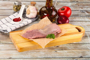 Raw pork tongue over board