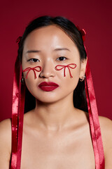 Creative makeup artistry showcased by beautiful young woman in vibrant studio