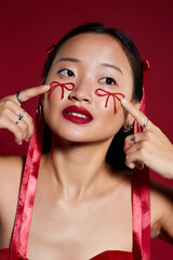 Creative beauty expression with red bows and lips by a young Asian woman