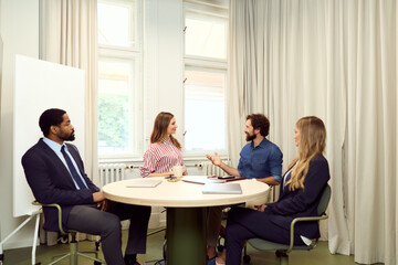 Professionals Collaborating in a Formal Business Meeting Around an Office Table