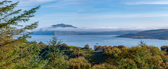 Blick über das Meer von der Isle of Mull Richtung Kilchoan – mit bewaldeten Hügeln, Highlands...