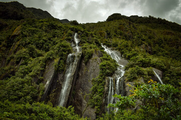 Waterfall in Franz Josef Valley rainforest, South Island New Zealand