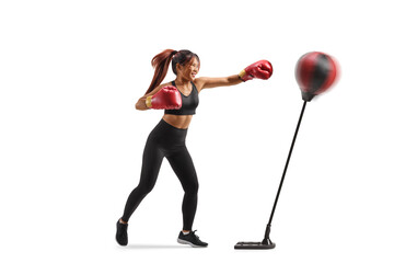 Active woman punching a stand with boxing gloves
