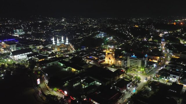 Samarinda, east borneo - September 5 2025: A aerial view of Samarinda city at night, there is the Cathedral Church of Santa Maria, the Eternal Helper, the Nurul Mu'minin Mosque, and Bank Kaltim.