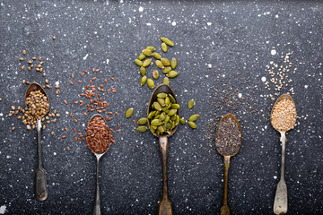 Pumpkin, sesame, flax, hemp, chia seeds in spoons, seeds for good health of mind and body, enriched...