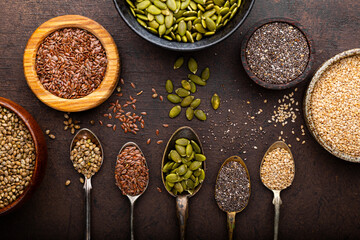 Pumpkin, sesame, flax, hemp, chia seeds in spoons and bowls, seeds for good health of mind and body, enriched with minerals and vitamins. Top view