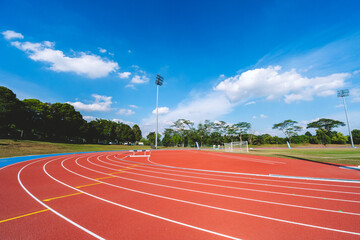 Empty running tracks at an outdoor athletics stadium featuring distinctive white lines and curves