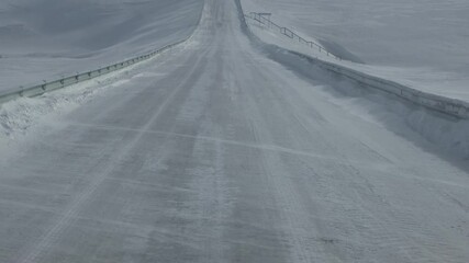 Blizzard accompanied by ground wind. Natirvik (blowing snows) and drifts on the roads. Siberia. Shooting in motion from the car cabin