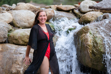 Enjoying a refreshing moment by a serene waterfall on a sunny day
