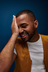 Trendy young man expressing joy and confidence in a vibrant urban setting