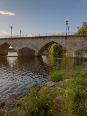 Stone bridge over the Tua River in Mirandela, Portugal, with granite arches and pedestrian use. August 2025, peaceful historic landmark connecting old city sides.