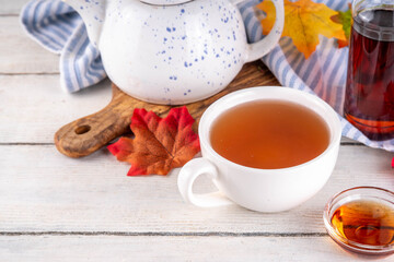 Sweet refreshing Maple hot Tea Drink, tasty aromatic warming beverage with ice cubes and a lot of maple syrup, copy space