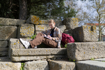 Fototapeta premium Archaeology student taking notes outdoors at historical site