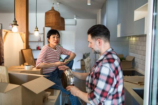 Couple organizing boxes in kitchen