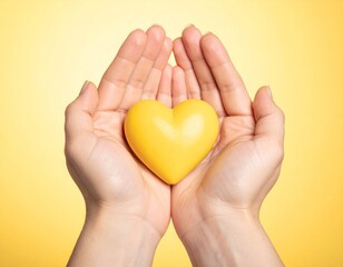 Woman's hands gently holding a yellow heart shape, a concept of giving love, kindness, health donation, and emotional support