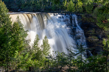 Kakabeka Falls, Ontario's stunning natural wonder, cascades powerfully through lush forests, offering mesmerizing scenic views and a serene escape into nature's beauty.