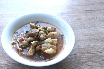 boiled slice braised beef meat with chili in clear tom yum soup on bowl 