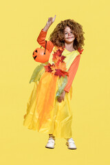 Cute curly girl in a costume for autumn and Halloween