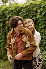Joyful couple enjoys a romantic stroll in the park amid lush greenery