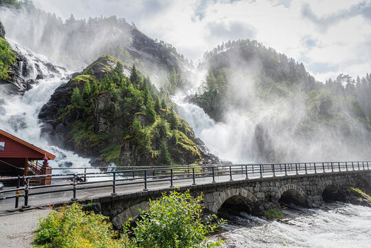 L&aring;tefossen Waterfall in Norway with a bridge in the foreground.