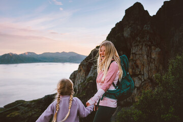 Mother hiking with daughter family vacations in Norway - parent and child exploring mountains in Lofoten Islands summer tour together camping adventure trip, happy candid emotions