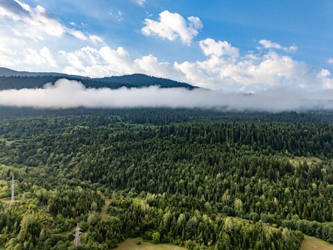 Aerial view of clouds covering green forest in Mestia, Georgia