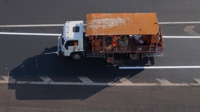 Workers Operating Machinery Applying Asphalt on Road Construction