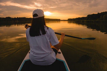Paddleboarding at Sunset on a Calm Lake