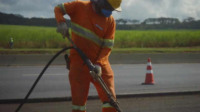 Workers Operating Machinery Applying Asphalt on Road Construction