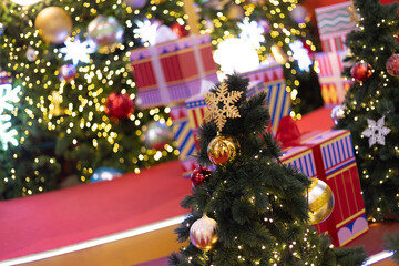 Several Christmas trees adorned with ornaments and lights brighten the evening atmosphere of a festive event shop inviting people to gather and celebrate