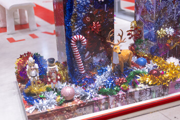 Several Christmas trees adorned with ornaments and lights brighten the evening atmosphere of a festive event shop inviting people to gather and celebrate