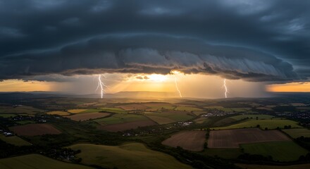 Breathtaking aerial perspective of a severe thunderstorm with multiple lightning strikes illuminating the countryside during a vibrant sunset