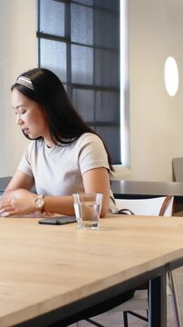 Vertical video: Diverse coworkers reviewing contract at office table editing signing shaking hands