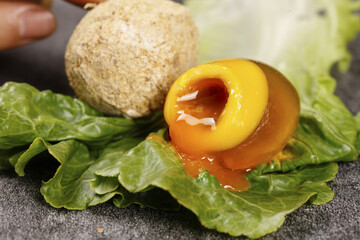 Chinese Preserved Egg with Golden Yolk on Lettuce Leaves - Traditional Asian Cuisine