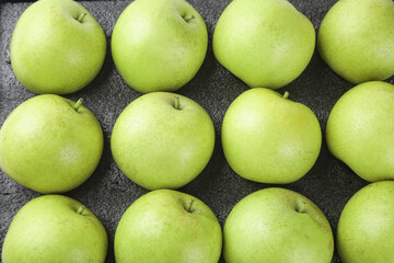 Fresh Green Apples Arranged in Rows on Dark Background
